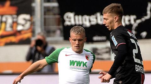 Augsburgs Philipp Max und Leverkusens Mitchell Weiser (l-r.) bemühen sich um den Ball. Foto: Stefan Puchner