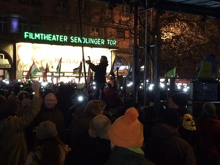 Die Gegendemonstranten machen ihre Handy-Lichter an.