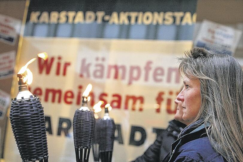 Hilfloser Prostest: Karstadt-Beschäftigte während einer Mahnwache mit Fackeln. Auch Manager fanden sich am Sonntag zu Protestaktionen ein. Foto: dpa