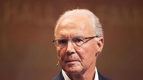 Franz Beckenbauer steht bei einer Veranstaltung auf der Bühne.