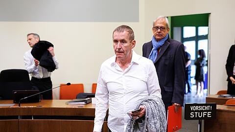 Manfred Genditzki (M) kommt in den Gerichtssaal am Landgericht München I. Hinter ihm betritt sein Rechtsanwalt den Saal.