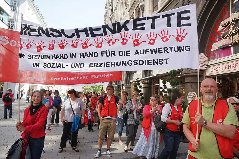 Erzieherinnen, Mütter und Sozialarbeiterinnen und Unterstützer bei Menschenkette am Marienplatz in München.