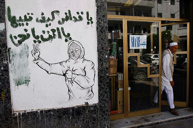 Diese Zeichnung warnt den untergetauchten Machthaber: "Hey Gaddafi, in Libyen ist nur Platz für einen von uns - Du oder WIR!" Die Rebellen nutzen die neuen Freiheiten seit Beginn der Ausschreitungen und machen sich in der Öffentlichkeit künstlerisch über Gaddafi lustig.
