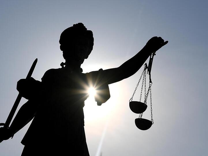 Die Statue der Justitia steht mit einer Waage und einem Schwert in der Hand. Foto: Arne Dedert/dpa/Archivbild