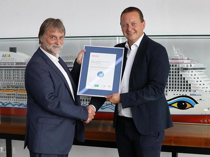 Ralf-Rainer Braun (l), Vorsitzender der Jury Umweltzeichen, überreicht Felix Eichhorn, Präsident von Aida Cruises, die Urkunde "Blauer Engel".