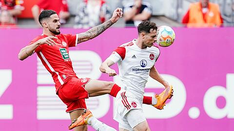 Kaiserslauterns Lex Tyger Lobinger (l) und Nürnbergs James Lawrence kämpfen um den Ball.