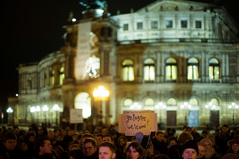 Eine Gegendemonstrantin protestiert am 15.12.2014 vor der Semperoper auf dem Theaterplatz in Dresden