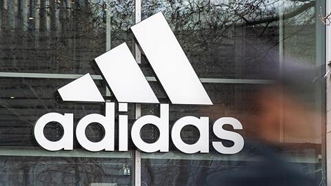 An der Fassade eines Adidas Stores hängt das Logo des Unternehmens.