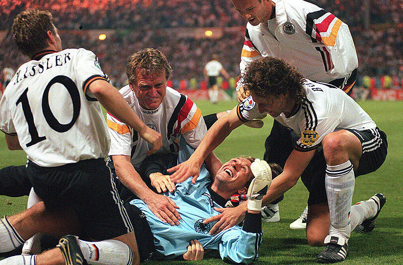 26. Juni 1996: Von seinen Mannschaftskameraden Thomas Häßler, Marco Bode, Fredi Bobic und von Torwart-Trainer Sepp Maier umjubelt, liegt der deutsche Torwart Andreas Köpke nach dem 6:5-Sieg im Elfmeterschießen beim Halbfinalspiel der Europameisterschaftgegen England am Boden.