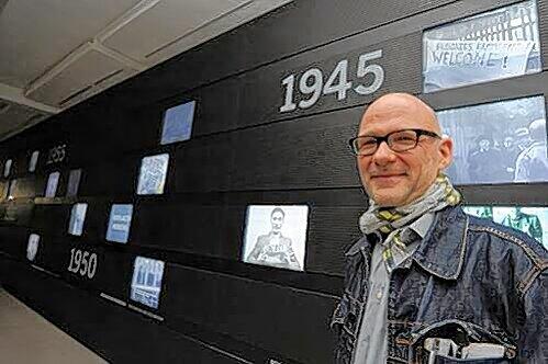 Ausstellungsmacher Ulrich Schwarz vor der Video-Wand, die die Entwicklung des Lagers seit 1945 dokumentiert.