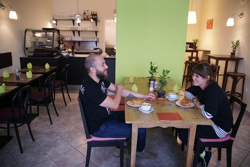 Das Café Flower ist schlicht eingerichtet. Der Holztisch im Vordergrund wurde Ende des 19. Jahrhunderts gefertigt und stammt aus einem alten Bauernhaus.