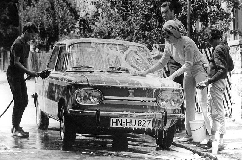 Die ganze Familie ist am Samstag damit beschäftigt, ihr Familienauto vom Typ NSU TT zu Waschen. Aufnahme von 1967.
