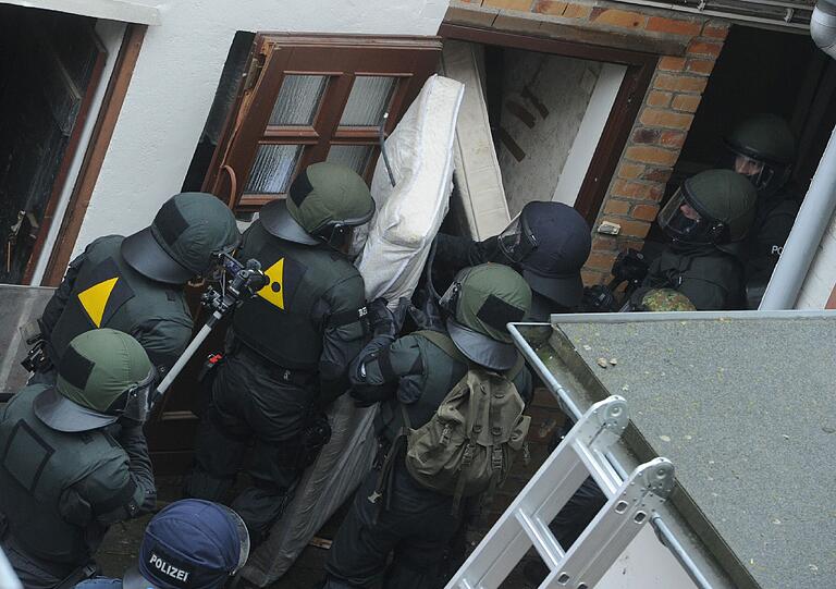 Die Besetzer werfen Konfetti, unten steht ein SEK-Kommando der Polizei: In Greifswald wurde ein besetztes Haus geräumt. Die Bilder.