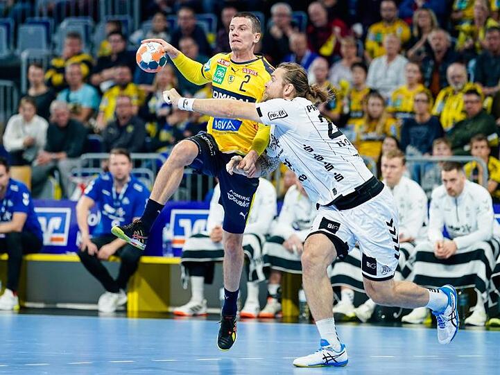 Rhein-Neckars Andy Schmid (l) und Kiels Pavel Horak kämpfen um den Ball.