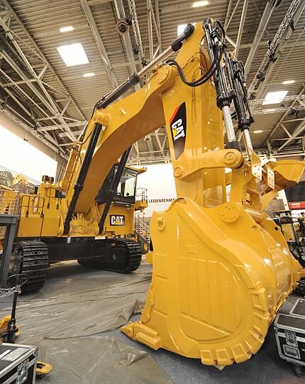 Einfach riesig: Der gelbe Gigant. Sein Arm wirkt wie der eines Riesen, seine Schaufel wie die Pranke des Herkules: Mit einem Einsatzgewicht von 220 Tonnen ist der Tieflöffel-Hydraulikbagger 6020B die größte Maschine der US-Firma Caterpillar auf der Bauma. Der 1300 PS gelbe Gigant wird in Minen eingesetzt &ndash; und ist laut Hersteller eine &bdquo;einfache, aber zuverlässige Maschine&ldquo;.