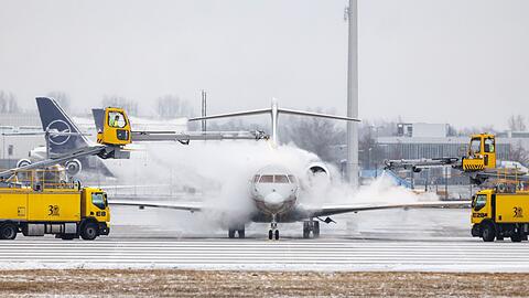 Ein Flugzeug wird kurz vor dem Start nahe der Startbahn auf dem Taxiway am Münchner Flughafen enteist.