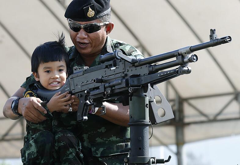 In Thailand ist der "Kinder-Tag". Dieser Junge freut sich über die Einweisung an einer Waffe.
