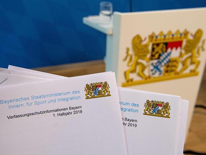 Der Verfassungsschutzbericht für das Jahr 2019 vor dem Wappen von Bayern. Foto: Lino Mirgeler/dpa/Archivbild
