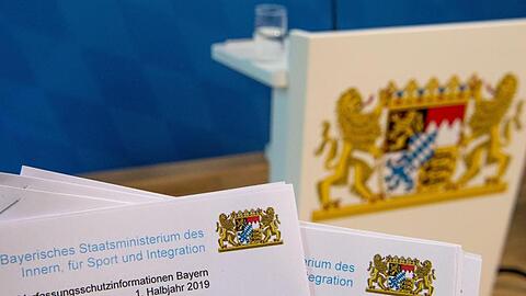 Der Verfassungsschutzbericht für das Jahr 2019 vor dem Wappen von Bayern. Foto: Lino Mirgeler/dpa/Archivbild
