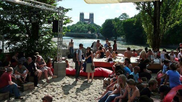 Warum die Veranstaltung nicht wieder an der Isar stattfindet? Der Standort für den Kulturstrand sollte regelmäßig wechseln, so die Idee. Während die Münchner 2013 noch auf der Corneliusbrücke auf den roten Säcken im Sand saßen...