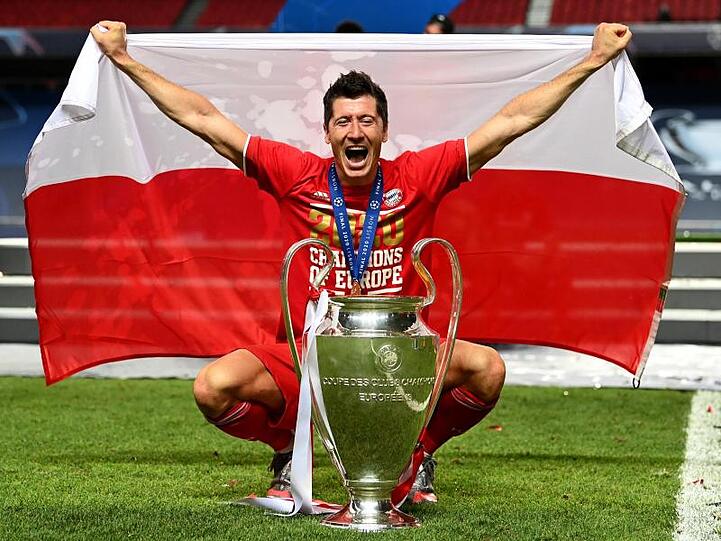 Robert Lewandowski posiert mit Polen-Fahne und Pokal. Foto: Michael Regan/Getty Images via UEFA/dpa