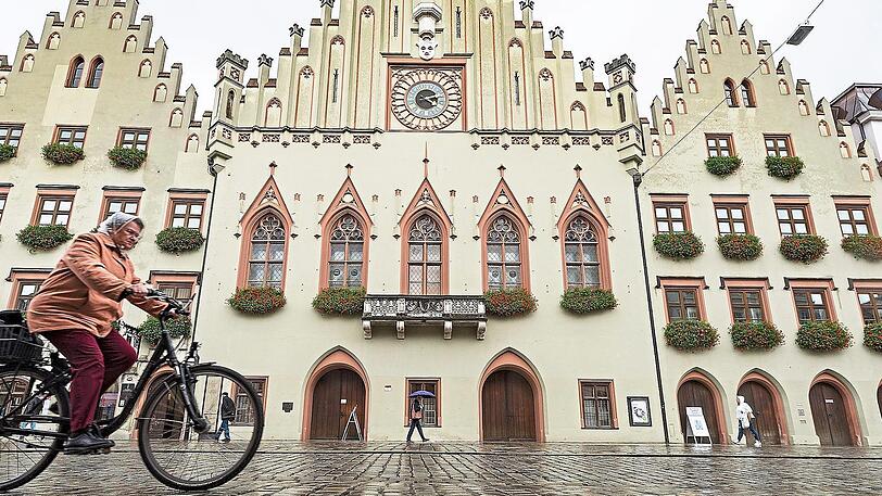 Radfahrerin vor dem Rathaus der Landshuter Altstadt.