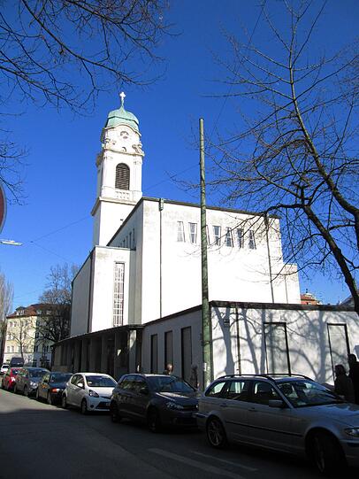 Los geht der Rundgang durch die Obere Au: Streng genommen noch in Haidhausen, aber ganz knapp an der Grenze zur Au ist die neubarocke Kirche St. Wolfgang am St.-Wolfgangs-Platz. Sie wurde zwischen 1915 und 1920 erbaut. Im Krieg blieb nur der Turm erhalten, erst in den 60er Jahren wurde die Kirche neu aufgebaut.