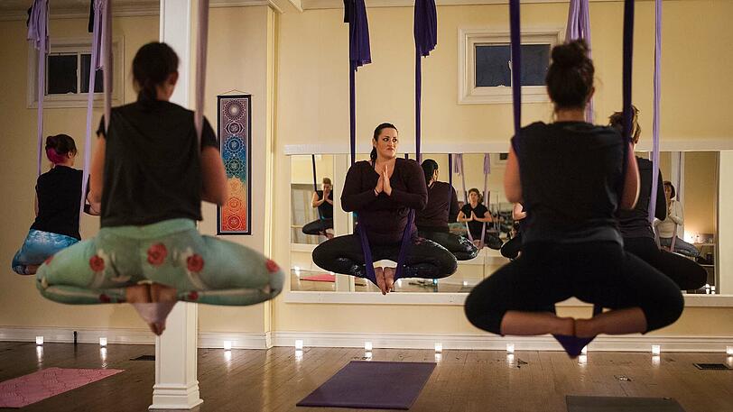 A - Aerial Yoga: Gibt es zwar schon länger, aber in diesem Jahr könnte die Yoga-Art, bei der man in einem von der Decke hängenden Tuch, ähnlich einer Hängematte, hängt oder sitzt, beliebter werden.