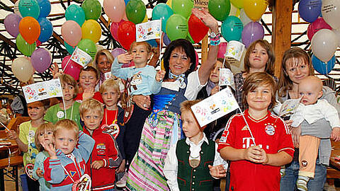 Gibt gerne Gas, wenn es darum geht, Gutes zu tun: Mietwagen-Königin Regine Sixt mit den Kindern auf der Oidn Wiesn.