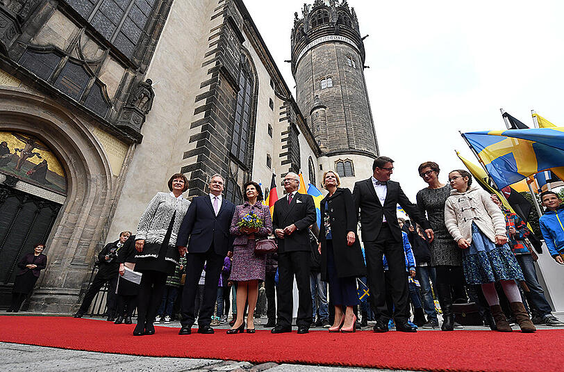 Sachsen-Anhalts Ministerpräsident Reiner Haseloff (CDU) und seine Ehefrau Gabriele (links) stehen an der Thesentür der Schlosskirche in Wittenberg neben Königin Silvia von Schweden, König Carl XVI. Gustaf sowie der schwedischen Außenministerin Marot Wallström.