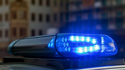 Das Blaulicht auf einem Fahrzeug der Polizei leuchtet in der Dunkelheit.