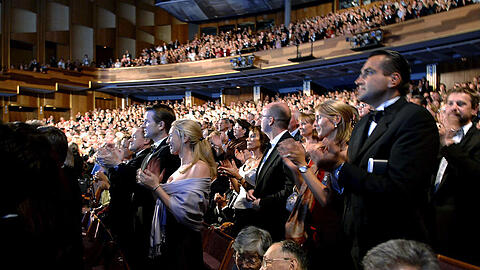 Smokings und Abendkleider nach der Premiere von Verdis Oper "La Traviata" im Juli 2005 bei den Salzburger Festspielen im Großen Festspielhaus. Heute sieht man weniger formelle Kleidung und am Rang ging es auch schon damals lockerer zu.