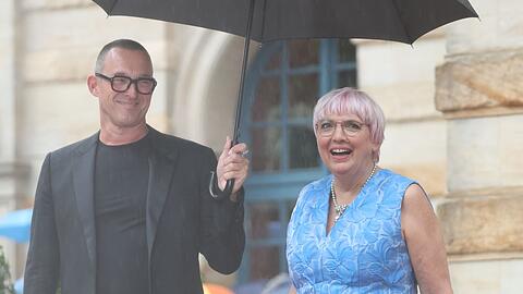 Kulturstaatsministerin Claudia Roth (Bündnis 90/Die Grünen) auf dem Weg zur Eröffnung der Wagner-Festspiele. Der Schriftsteller Albert Ostermaier hält ihren Schirm.