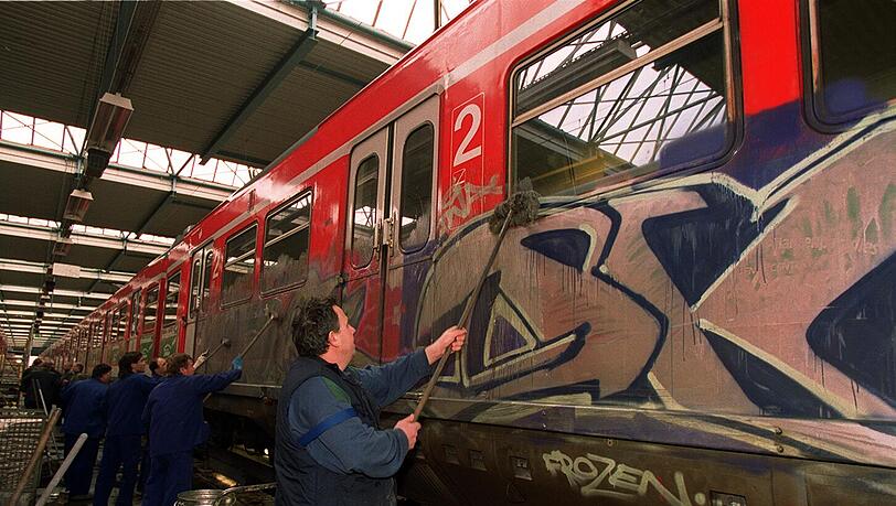 Arbeiter entfernen Graffiti an einer S-Bahn. Arbeiter entfernen Graffiti an einer S-Bahn.