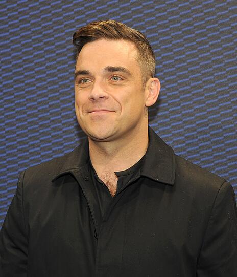 Weltstar im Fan-Gewusel: Robbie Williams verteilte Autogramme vor dem Mathäser-Kino.