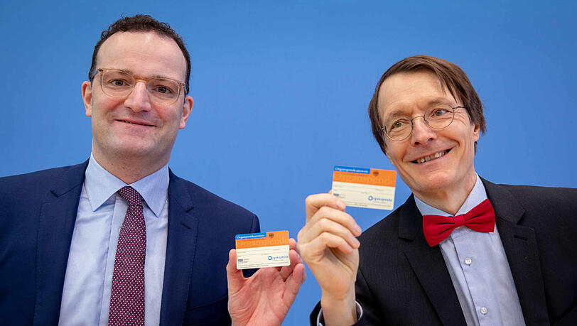 Gesundheitsminister Jens Spahn (CDU, l.) und Karl Lauterbach (SPD) halten einen Organspendeausweis in der Hand.