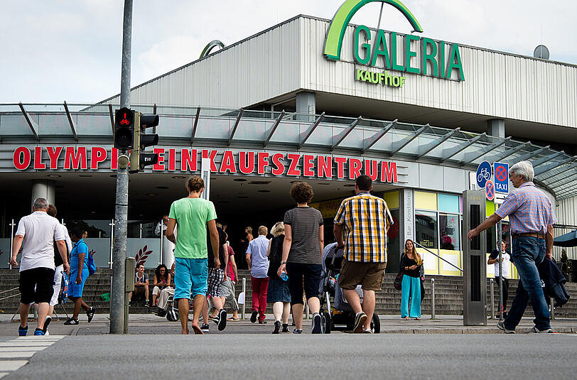 Vier Wochen nach dem Amoklauf: Passanten gehen am Donnerstag über eine Ampel vor dem Olympia Einkaufszentrum in München.