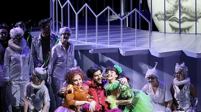 Jennifer O'Loughlin (Frau Fluth, links), Levente Páll (Sir John Falstaff) und Anna-Katharina Tonauer (Frau Reich) mit dem Chor des Staatstheaters.