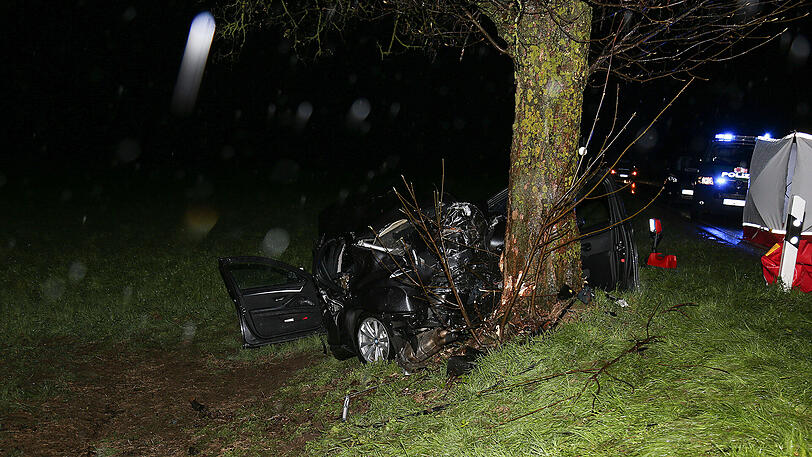 Schreckliche Bilder aus Icking: Der BMW kam von der Straße ab und prallte gegen einen Baum. Zwei 19-jährige Männer starben.