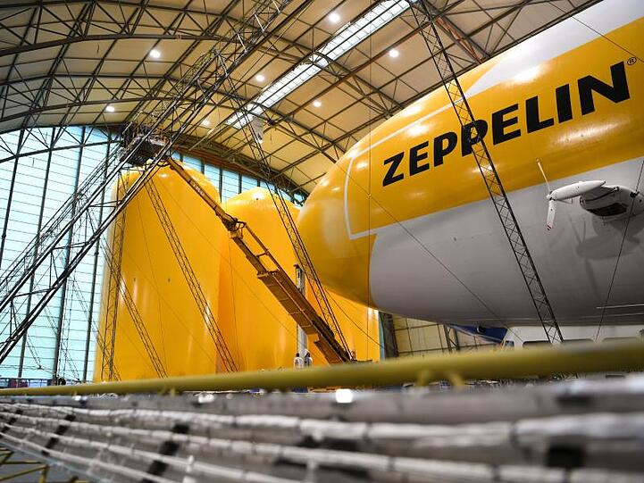 Zwei Techniker arbeiten auf einer Hebebühne an einem Zeppelin NT (Neue Technik). Foto: Felix Kästle/dpa/Archivbild