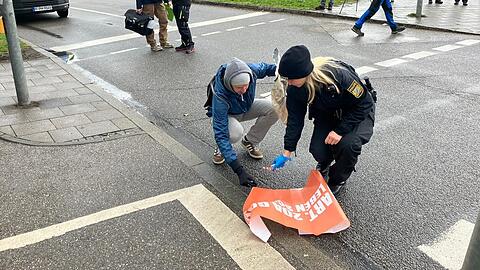 Eine Polizistin und ein Aktivist räumen zusammen.