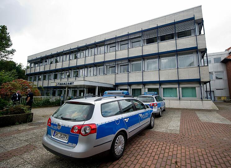 Polizeifahrzeuge stehen am 01.09.2014 in Rendsburg (Schleswig-Holstein) vor dem Finanzamt. Ein Mitarbeiter des Finanzamts ist von einem Kunden erschossen worden.