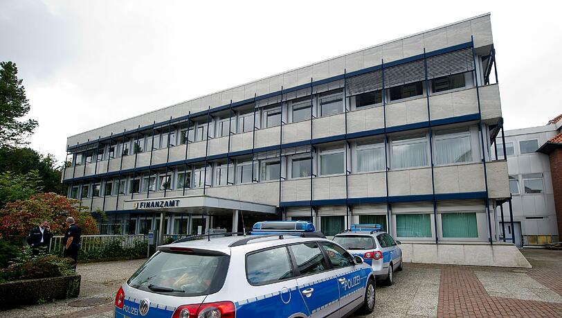 Polizeifahrzeuge stehen am 01.09.2014 in Rendsburg (Schleswig-Holstein) vor dem Finanzamt. Ein Mitarbeiter des Finanzamts ist von einem Kunden erschossen worden. Polizeifahrzeuge stehen am 01.09.2014 in Rendsburg (Schleswig-Holstein) vor dem Finanzamt. Ein Mitarbeiter des Finanzamts ist von einem Kunden erschossen worden.