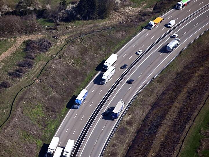 Luftbild von einer Autobahn, auf der Lkw fahren.
