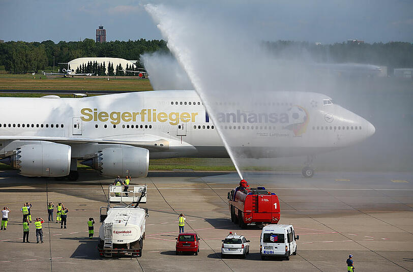 Der Flieger rollt unter der Willkommens-Dusche der Berliner Feuerwehr durch.