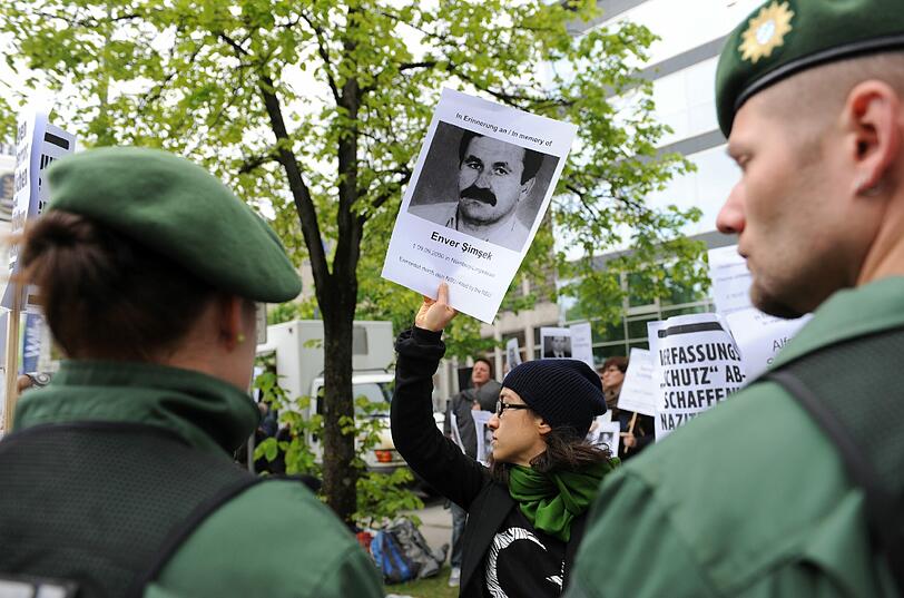 Bilder vom Prozess-Auftakt: Eine Demonstrantin hält vor dem Gerichtsgebäude ein Foto des ersten NSU-Mordopfers Enver Simsek in die Höhe.