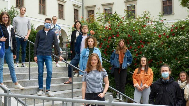 Die Initiatoren einer Petition gegen das Donaulied stehen verteilt auf einer Treppe. (Archivbild)