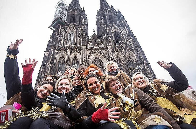 Diese Jecken feiern das Leben und sich selbst vor dem Kölner Dom.