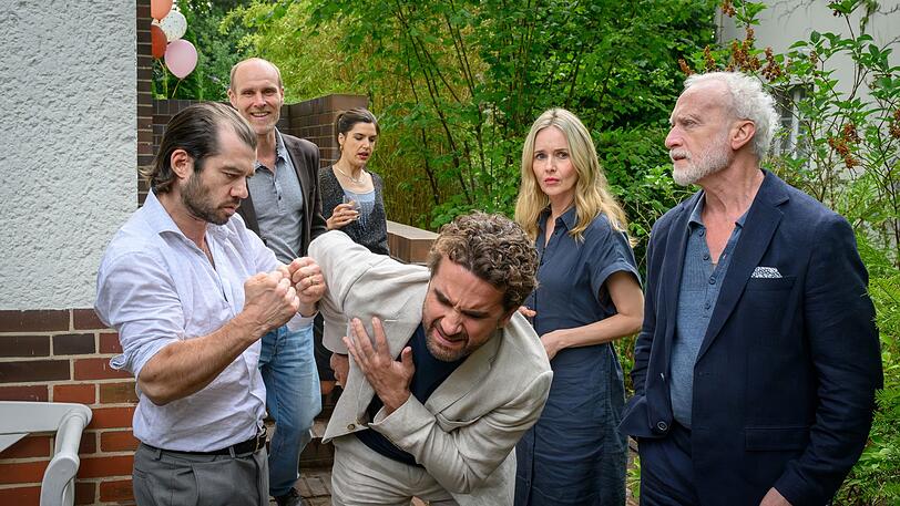 Galinas Bruder Andrej (Nikolas Garin, links) und ihr Vater Gennadij (Grigory Kofman, rechts) finden, dass Markus (Oliver Wnuk, Mitte) wissen muss, wie ein "echter Mann" seine Frau verteidigt. Hape (Niels Bormann), Miriam (Stefanie Stappenbeck, zweite von rechts) und Andrea (Sophia Mercedes Burtscher) sind skeptisch. Galinas Bruder Andrej (Nikolas Garin, links) und ihr Vater Gennadij (Grigory Kofman, rechts) finden, dass Markus (Oliver Wnuk, Mitte) wissen muss, wie ein "echter Mann" seine Frau verteidigt. Hape (Niels Bormann), Miriam (Stefanie Stappenbeck, zweite von rechts) und Andrea (Sophia Mercedes Burtscher) sind skeptisch.