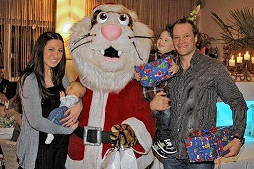 Nikolaus Pucki hatte bei der Tigers-Weihnachtsfeier viel  zu tun: Hier beschenkt er die Familie Wilm, Papa Clarke, Söhnchen Ryder und Mama Andrea mit Baby Logan.